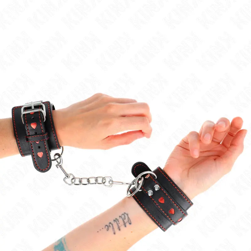 KINK - MUÑEQUERAS NEGRO CON INCRUSTACIÓN DE CORAZÓN ROJO AJUSTABLE 21-28 CM X 5.5 CM KINK WRIST RESTRAINT